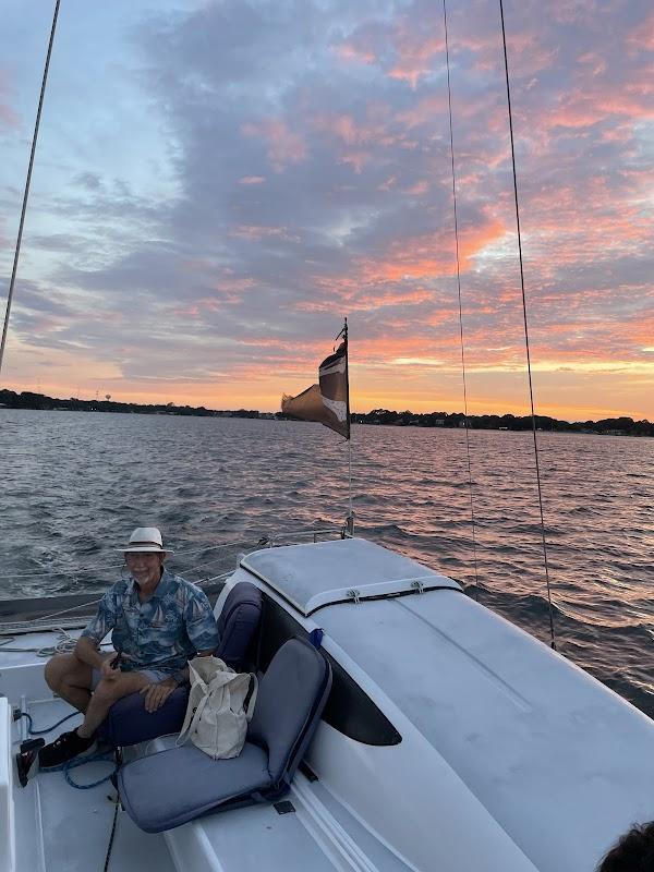 Man relaxing on the deck of a 1st Choice Charter boat during a sunset cruise in Destin, Florida.