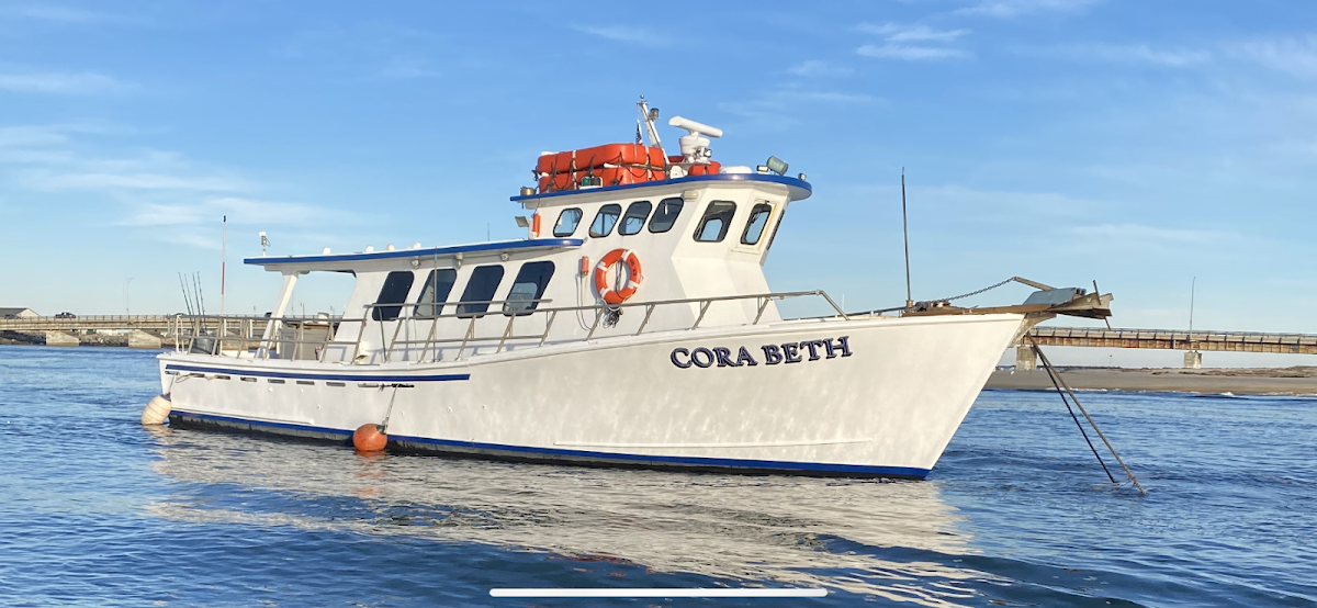 Cora Beth charter fishing boat anchored in blue Key West waters with clear skies in background