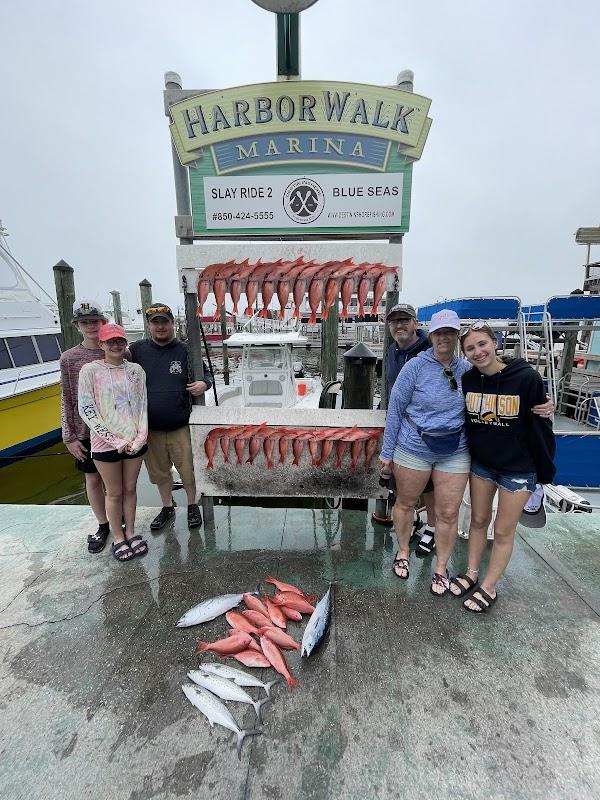 A happy group of anglers posing with their impressive red snapper catch at HarborWalk Marina with Destin Inshore Fishing Co.