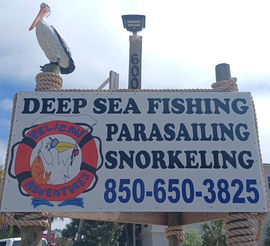 Pelican Adventures business sign featuring a pelican logo and listing services: Deep Sea Fishing, Parasailing, Snorkeling